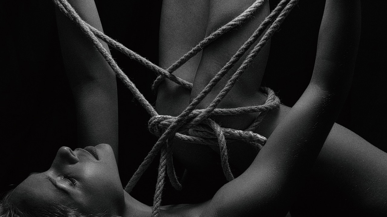 femme avec de la corde autour des jambes, pratiquant le shibari